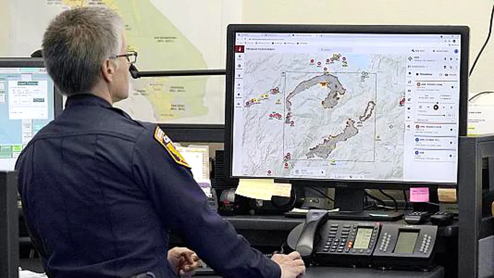 Đại úy cứu hỏa Danell Eshnaur sử dụng chương trình  “Phân tích chiến thuật phản ứng đám cháy” giúp định vị  trước các nguồn lực chữa cháy ở bang California ngày 23-7. Ảnh: AP