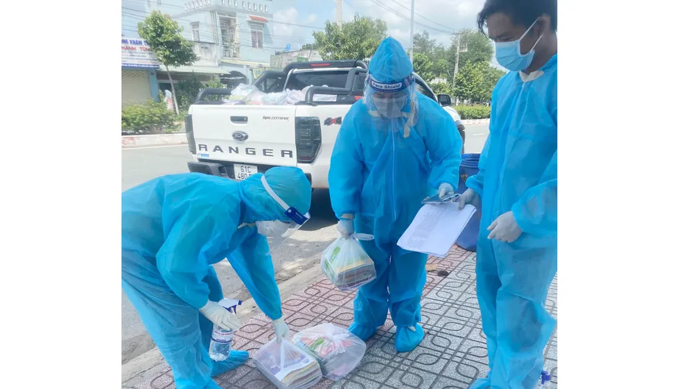 Giáo viên Trưởng THCS Mỹ Thạnh (thị xã Bến Cát, tỉnh Bình Dương) chuẩn bị SGK đến các em học sinh ở vùng đỏ