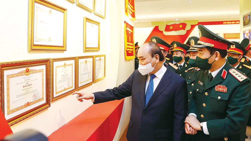 Chủ tịch nước Nguyễn Xuân Phúc và Đại tướng Phan Văn Giang cùng các đại biểu tham quan Nhà truyền thống của Trường Sĩ quan Chính trị