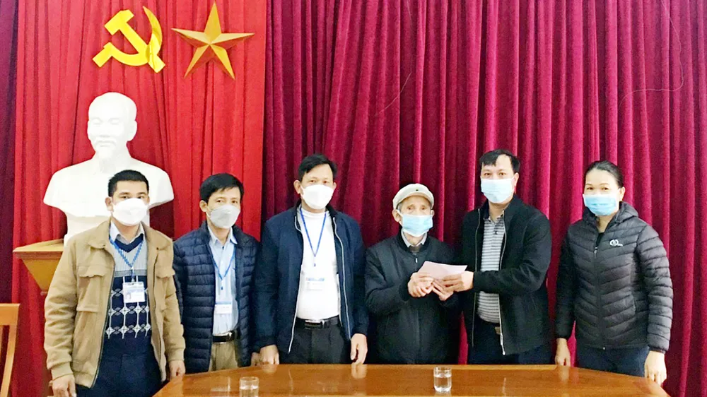 Cụ Đàm Điệt trao sổ tiết kiệm 100 triệu đồng  ủng hộ quỹ phòng chống dịch COVID-19  xã Hưng Thông (Nghệ An). Ảnh: TTXVN