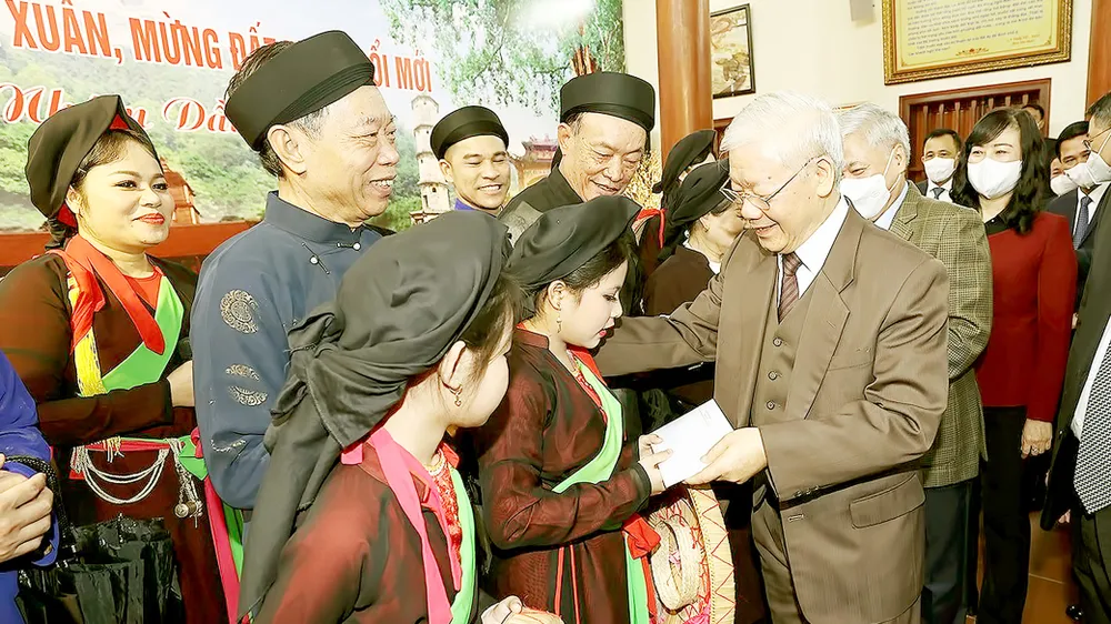 Tổng Bí thư Nguyễn Phú Trọng tặng quà Tết liền anh, liền chị Quan họ tại Di tích lịch sử -  văn hóa Đền Đô ở khu phố Thượng, phường Đình Bảng, thành phố Từ Sơn, tỉnh Bắc Ninh. Ảnh: TTXVN