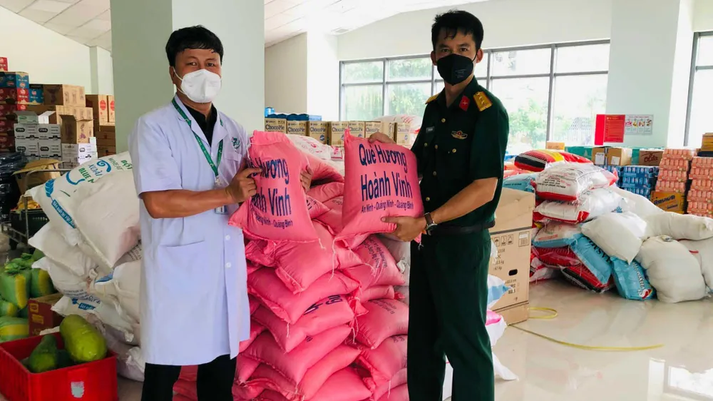 Bác sĩ Nguyễn Xuân Thành chuyển từng bao gạo do bà con ở quê ủng hộ lực lượng tuyến đầu chống dịch ở TPHCM