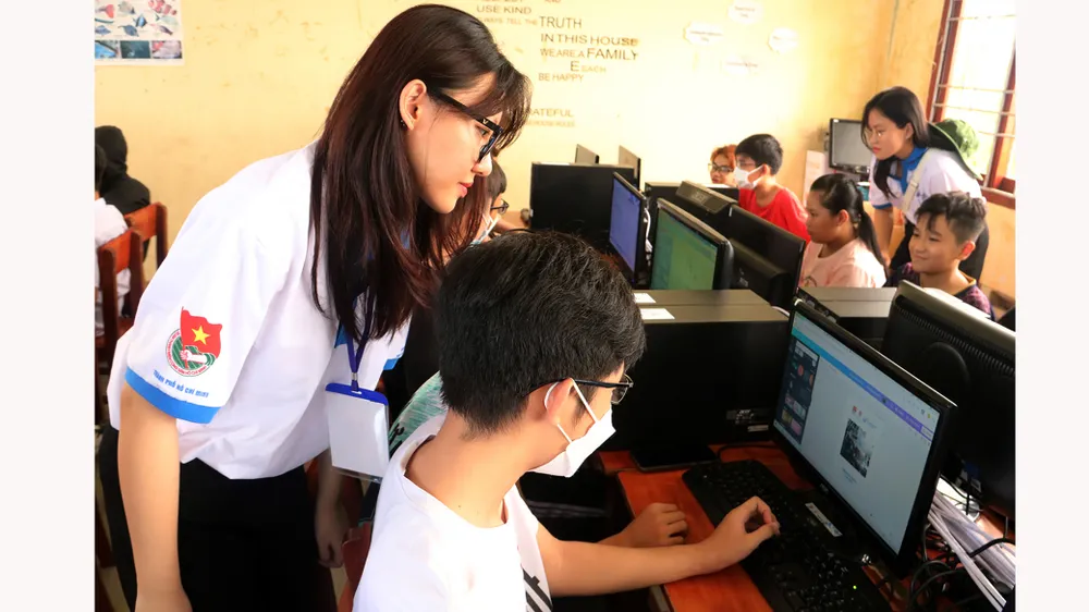 Nguyễn Thị Ngọc Ánh cùng đồng đội hướng dẫn học sinh  ở huyện Tháp Mười, tỉnh Đồng Tháp  sử dụng công nghệ thông tin. Ảnh:  Ngô Bình
