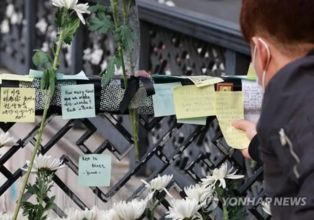 Một người đàn ông đăng thông điệp chia buồn vào ngày 1-11-2022, gần ga Itaewon cho những người thiệt mạng trong vụ giẫm đạp trong lễ hội Halloween tại Itaewon. Ảnh: Yonhap