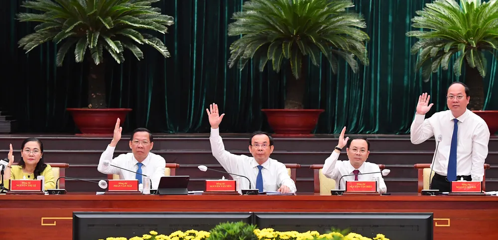 Các đồng chí lãnh đạo TPHCM biểu quyết thông qua nghị quyết hội nghị. Ảnh: VIỆT DŨNG