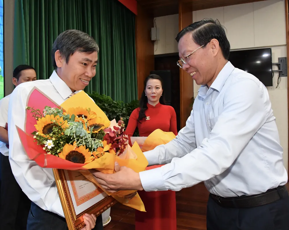 Chủ tịch UBND TPHCM Phan Văn Mãi tặng bằng khen của Thủ tướng Chính phủ cho ông Nguyễn Văn Đầy. Ảnh: VIỆT DŨNG