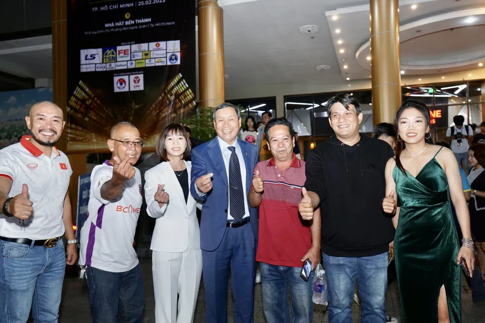 HLV Mai Đức Chung và nữ cầu thủ Huỳnh Như chụp hình kỷ niệm với người hâm mộ