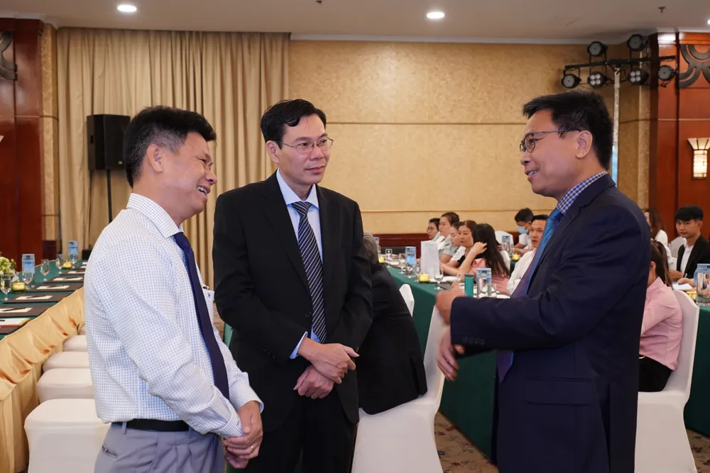 Nhà báo Phạm Văn Trường trao đổi với các đại biểu bên lề hội nghị. Ảnh: HOÀNG HÙNG