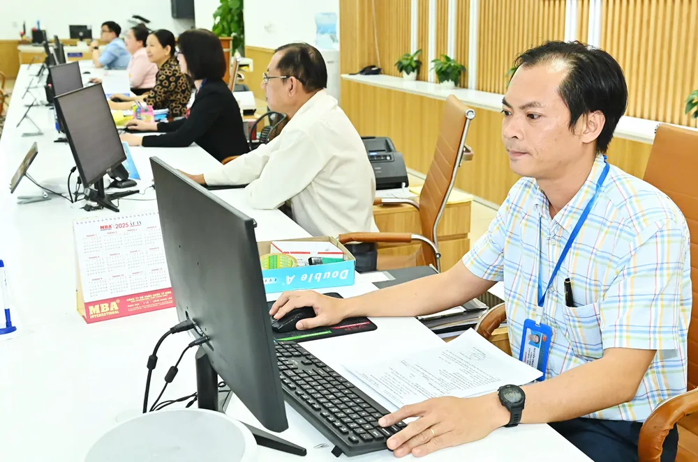 Cán bộ công chức làm việc tại Bộ phận tiếp nhận và trả kết quả của quận 6. Ảnh: VIỆT DŨNG 