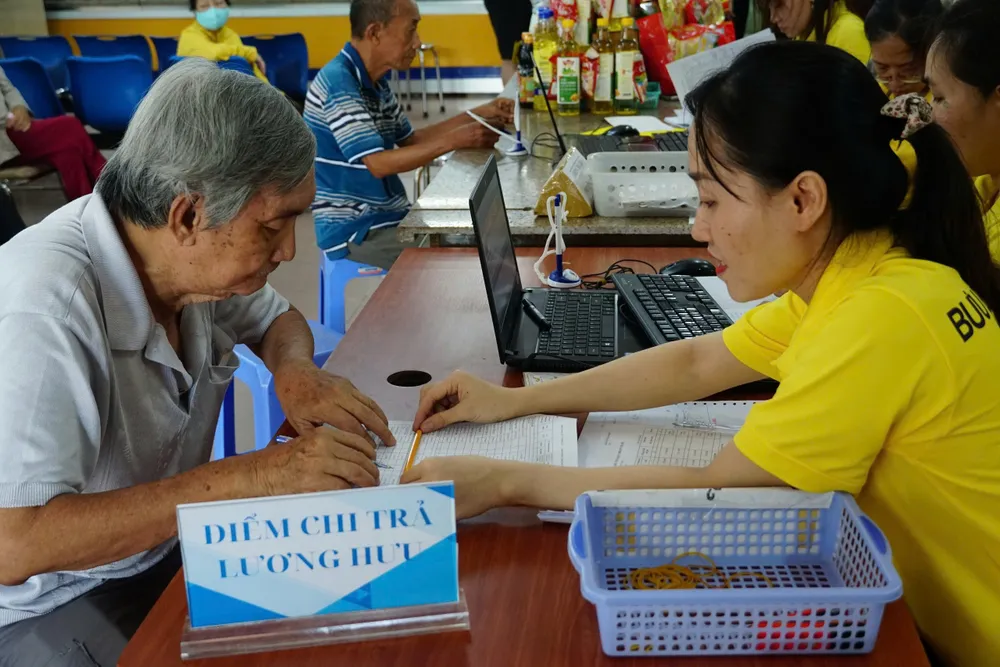 Nhân viên Bưu điện TPHCM chi trả lương hưu. Ảnh: ĐÔNG SƠN