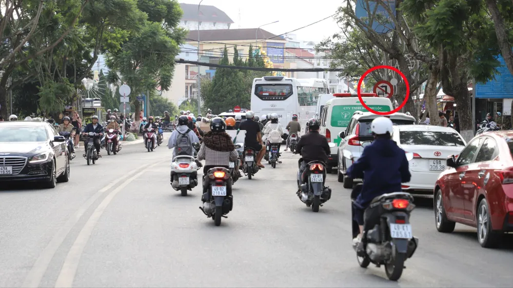 Biển báo cấm ô tô rẽ trái tại nút giao Nguyễn Văn Cừ - Bà Triệu, phường Xuân Hương-Đà Lạt (khoanh tròn) bị che khuất, khiến người điều khiển phương tiện không kịp quan sát thường xuyên bị phạt nguội tại đây. Ảnh: ĐOÀN KIÊN
