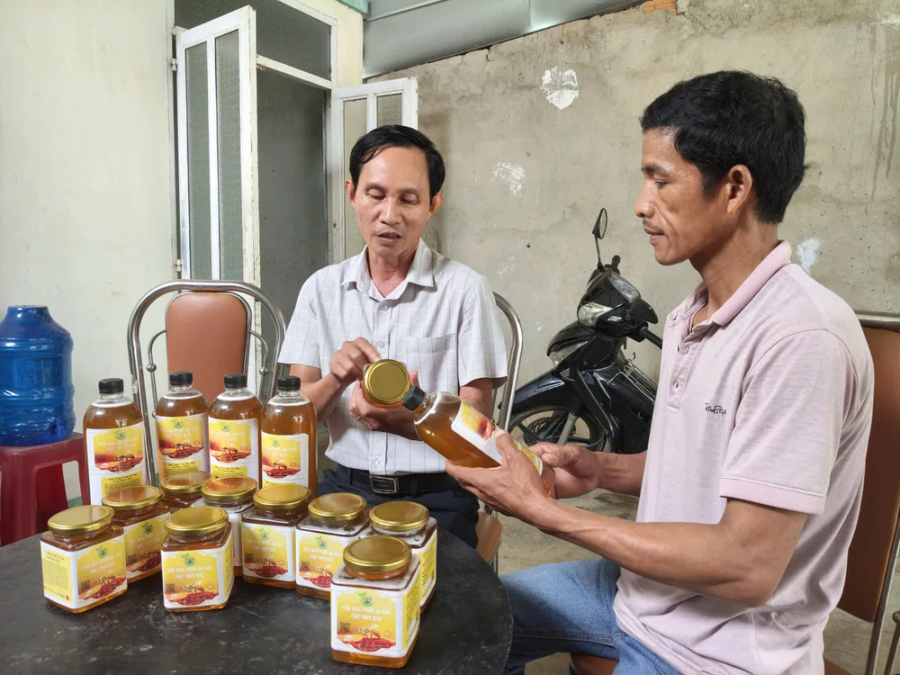 Ông Nguyễn Hồng Châu (bên phải) thuyết minh về sản phẩm mật ong do người dân sản xuất