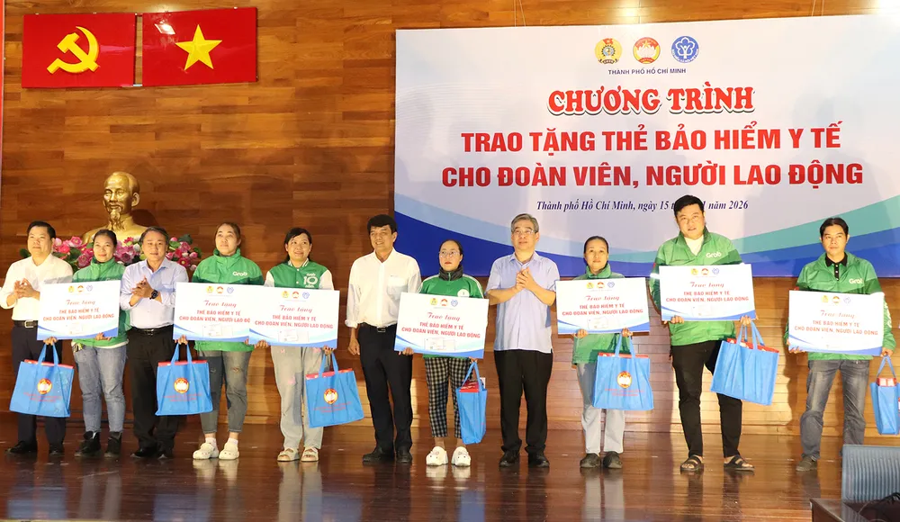 Phó Bí thư Thành ủy TPHCM Nguyễn Phước Lộc (giữa) trao thẻ BHYT và quà đến người lao động khó khăn