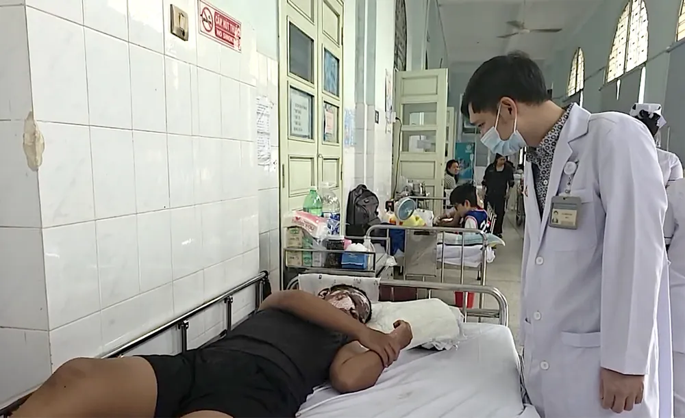 BS Ngô Hồng Phúc, Trưởng khoa Bỏng - Chỉnh trực, Bệnh viện Nhi đồng 2, thăm khám cho bệnh nhi bỏng nặng do pháo nổ. Ảnh: MINH KHUÊ