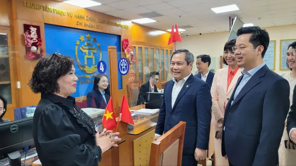 Chủ tịch UBND TP Hà Nội Vũ Đại Thắng trao đổi với một công dân đến làm thủ tục hành chính tại Trung tâm Phục vụ hành chính công chi nhánh số 3. Ảnh: QUỐC KHÁNH