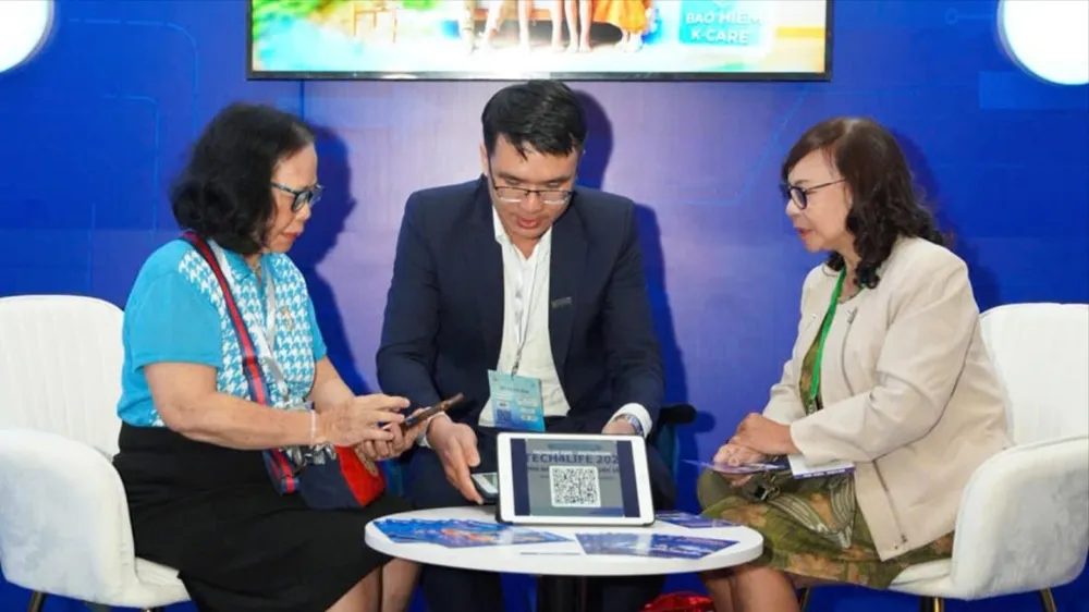 Nhân viên Sacombank hướng dẫn khách hàng trải nghiệm giao dịch số. Ảnh: MINH HUY