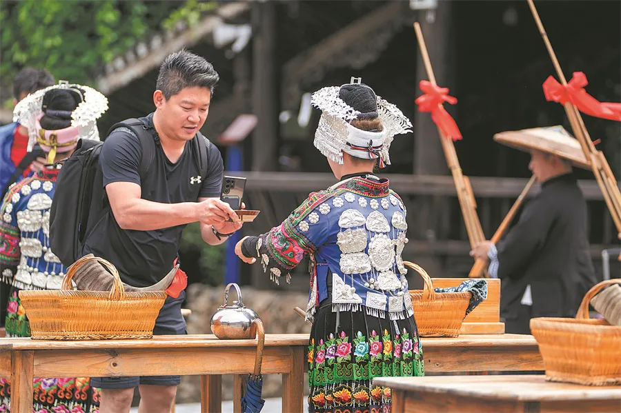 Trải nghiệm văn hóa tại Tây Giang Thiên Hộ Miêu Trại. Ảnh: CHINA DAILY