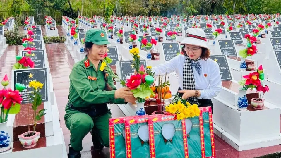 Bà Tân Thị Ngọc Bích (bên trái) và nữ hội viên chuẩn bị lễ vật cúng trước khi thực hiện nghi thức cất bốc, di dời hài cốt liệt sĩ