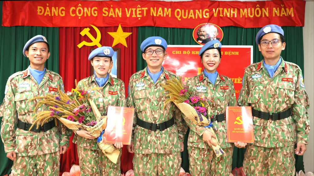 Tặng hoa chúc mừng 2 nữ đảng viên mới. Ảnh GGHBVN