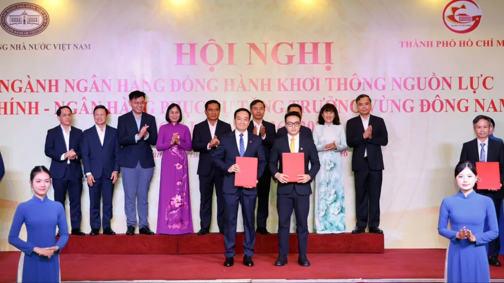 Đại diện các ngân hàng trao thỏa thuận hợp tác cho doanh nghiệp tại hội nghị. Ảnh: HOÀNG TRIỀU