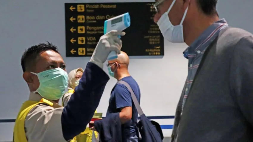 A health officer checks the temperature of an arriving passenger at Jakarta's Soekarno-Hatta International Airport. (Photo by Ken Kobayashi)