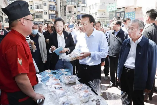 Thủ tướng Lý Khắc Cường ghé thăm một quầy bán hàng rong. (Ảnh: THX)