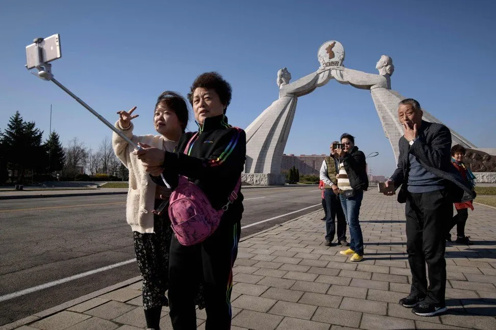 Tourists from China pose for photos before the Three Charters monument in Pyongyang in April 2019. Photo: AFP