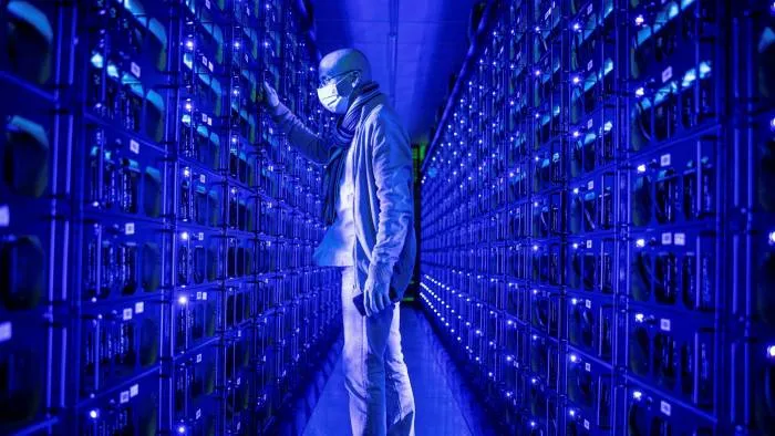 Một nhân viên đeo khẩu trang bảo vệ kiểm tra các hệ thống đào tiền điện tử Ethereum và Zilliqa tại trang trại tiền điện tử Evobits ở Cluj-Napoca, Romania © Bloomberg