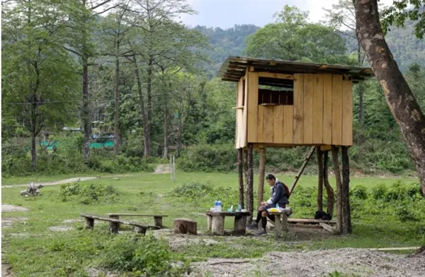 Quốc vương Bhutan Jigme Khesar Namgyel Wangchuck dùng bữa trưa tại một tiền đồn an ninh trong chuyến thăm của ông đến một ngôi làng hẻo lánh. Ảnh: Reuters.
