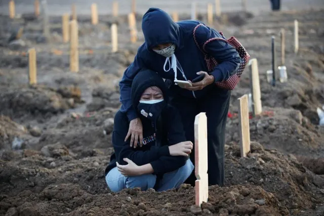 Một phụ nữ Indonesia khóc nấc bên nấm mộ sơ sài của người thân qua đời vì Covid-19 ngày 28/6. Ảnh: Reuters. Indonesia bên bờ thảm họa Covid-19 vì biến thể Delta ảnh 1