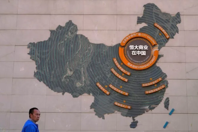 Một người đứng gần tấm bản đồ các dự án phát triển của Evergrande trên bức tường ở quảng trường thành phố ở Bắc Kinh, ngày 21 tháng 9. (Ảnh AP)