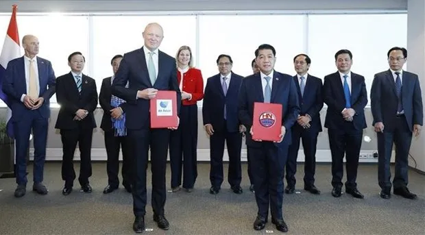 Prime Minister Pham Minh Chinh (C) witnesses the signing and exchange of cooperation documents between Vietnamese and Dutch businesses and partners (Photo: VNA)