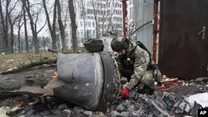 Một sĩ quan Ukraine kiểm tra bộ phận tên lửa gần một tòa nhà dân cư bị hư hại do cuộc tấn công bằng tên lửa của Nga ở Kharkiv, Ukraine, ngày 2/1/2024.