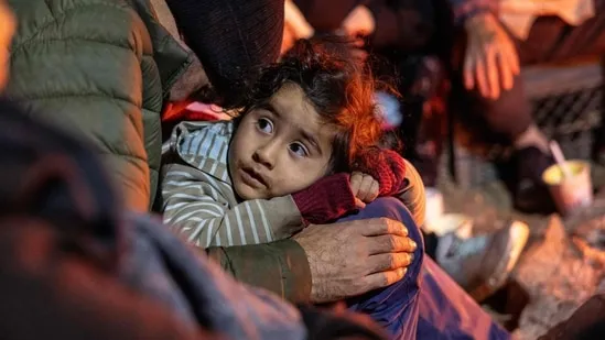 Những người nhập cư từ Afghanistan sưởi ấm bên đống lửa tại một trại trung chuyển ở biên giới Hoa Kỳ-Mexico gần Sasabe, Arizona. (Getty Images qua AFP)