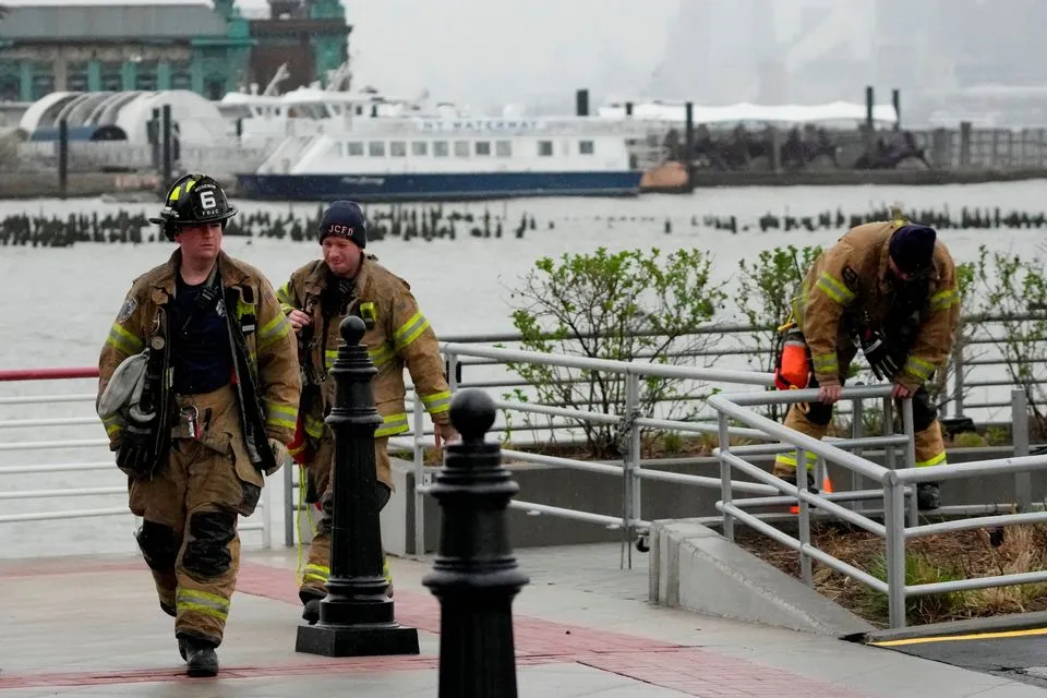 Nhân viên cứu hộ hoạt động sau khi một chiếc trực thăng rơi xuống sông Hudson gần hạ Manhattan ở New York, tại Newport, New Jersey, Hoa Kỳ, ngày 10 tháng 4 năm 2025. REUTERS/Eduardo Munoz