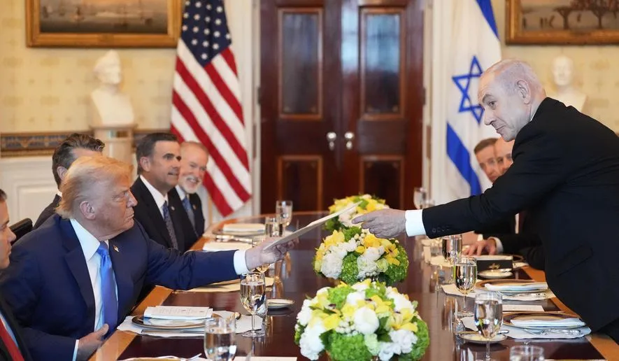 Thủ tướng Israel Benjamin Netanyahu, bên phải, trao cho Tổng thống Donald Trump một tập tài liệu trong cuộc họp tại Phòng Xanh của Nhà Trắng, thứ Hai, ngày 7-7-2025, tại Washington. 