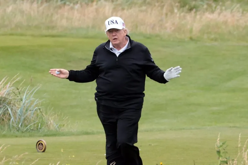 Tổng thống Hoa Kỳ Donald Trump vẫy tay chào giới truyền thông khi chơi golf tại Câu lạc bộ Golf Turnberry ở Scotland hôm 27-7. Sau đó, ông gặp Chủ tịch Ủy ban Châu Âu Ursula von der Leyen. Ảnh: Hugo Philpott/UPI 