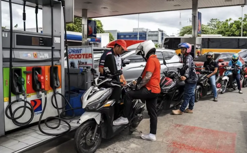 Người dân xếp hàng đổ xăng tại một trạm xăng ở Manila. Ảnh: CNA