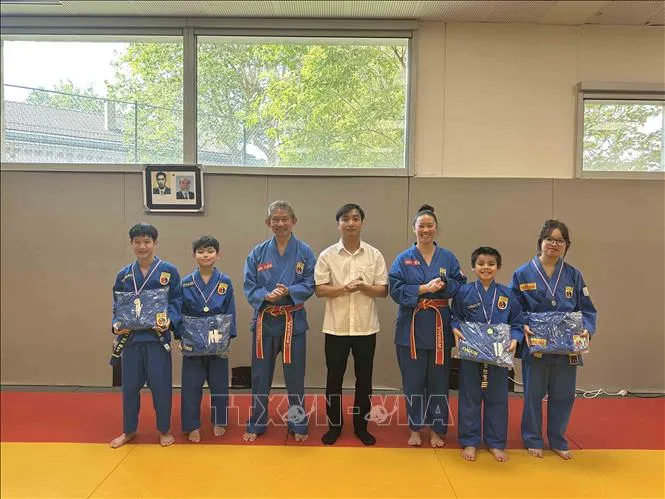 Chủ tịch CLB Thăng Long Thủy Tiên (thứ ba từ phải sang) cùng cha của mình (thứ ba từ trái qua) và đại diện TTVH Việt Nam tại Pháp, trao thưởng cho học viên có thành tích cao của CLB. Ảnh: TTXVN