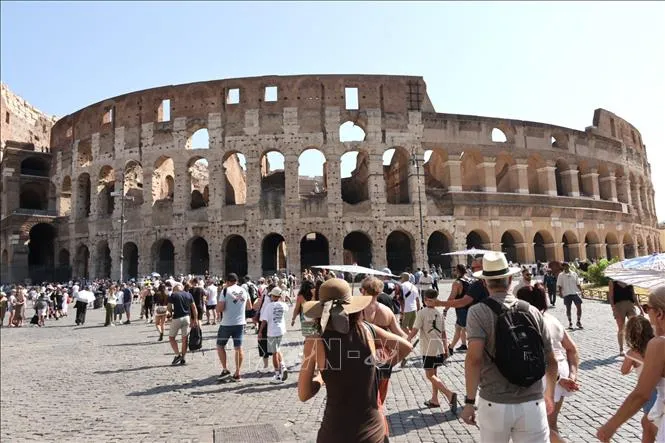 Bất chấp thời tiết nắng nóng gay gắt, du khách đổ về Đấu trường Colosseum ở Rome, Italy. Ảnh: TTXVN