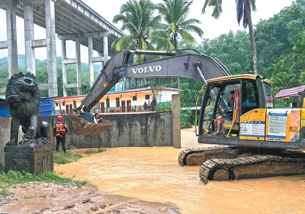 Lực lượng cứu hỏa sử dụng máy xúc để giải cứu 14 người bị mắc kẹt do nước lũ tại Ngũ Chỉ Sơn, tỉnh Hải Nam, vào hôm 14-9. Ảnh: China Daily