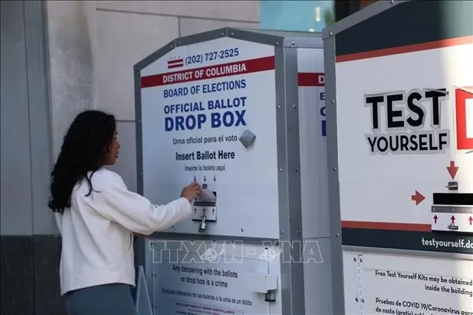 Cử tri bỏ phiếu qua hòm thư của USPS tại điểm bầu cử Thư viện Cleveland Park, Washington D.C. Ảnh tư liệu: TTXVN 