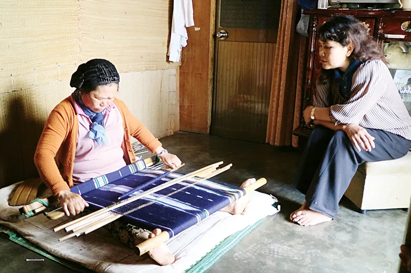 Nghệ nhân Cơ Liêng K’Phước bên khung dệt và Rơ Ông K’Ương