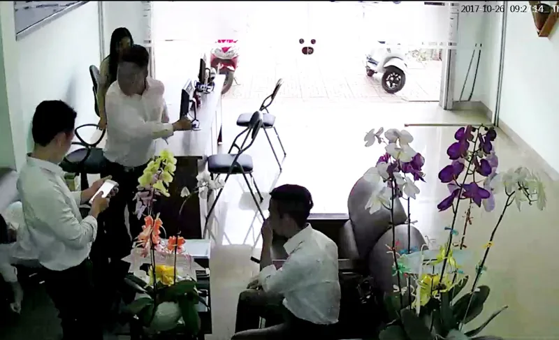 Ông Thiện (người đứng thứ 2 từ phải qua) đánh ông Bình xuống ghế. Ảnh chụp lại từ camera an ninh của văn phòng luật sư L.Q.T.
