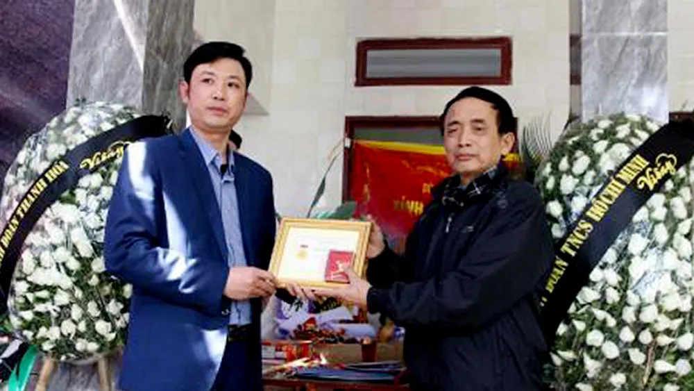 Bí thư Tỉnh đoàn Thanh Hóa Lê Văn Trung truy tặng Huy hiệu “Tuổi trẻ dũng cảm” cho thân nhân em Hoàng Đức Hải. Ảnh: TTXVN