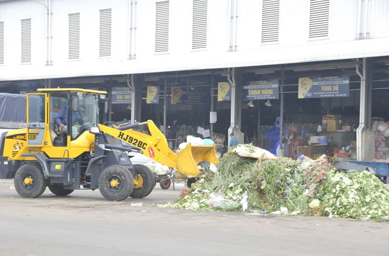 Thu gom rác từ rau, củ, quả tại chợ đầu mối Bình Điền  Ảnh: THÀNH TRÍ