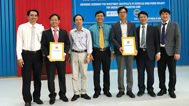 Ông Phạm Văn Tám (áo xanh), Trưởng Ban Quản lý Khu kinh tế tỉnh Trà Vinh trao giấy chứng nhận cho nhà đầu tư Dự án Nhà máy điện gió Duyên Hải