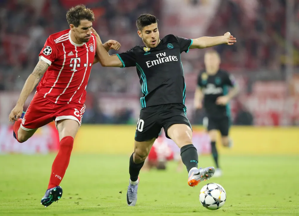 Marco Asensio (phải) vượt qua J. Martinez của Bayern Munich.