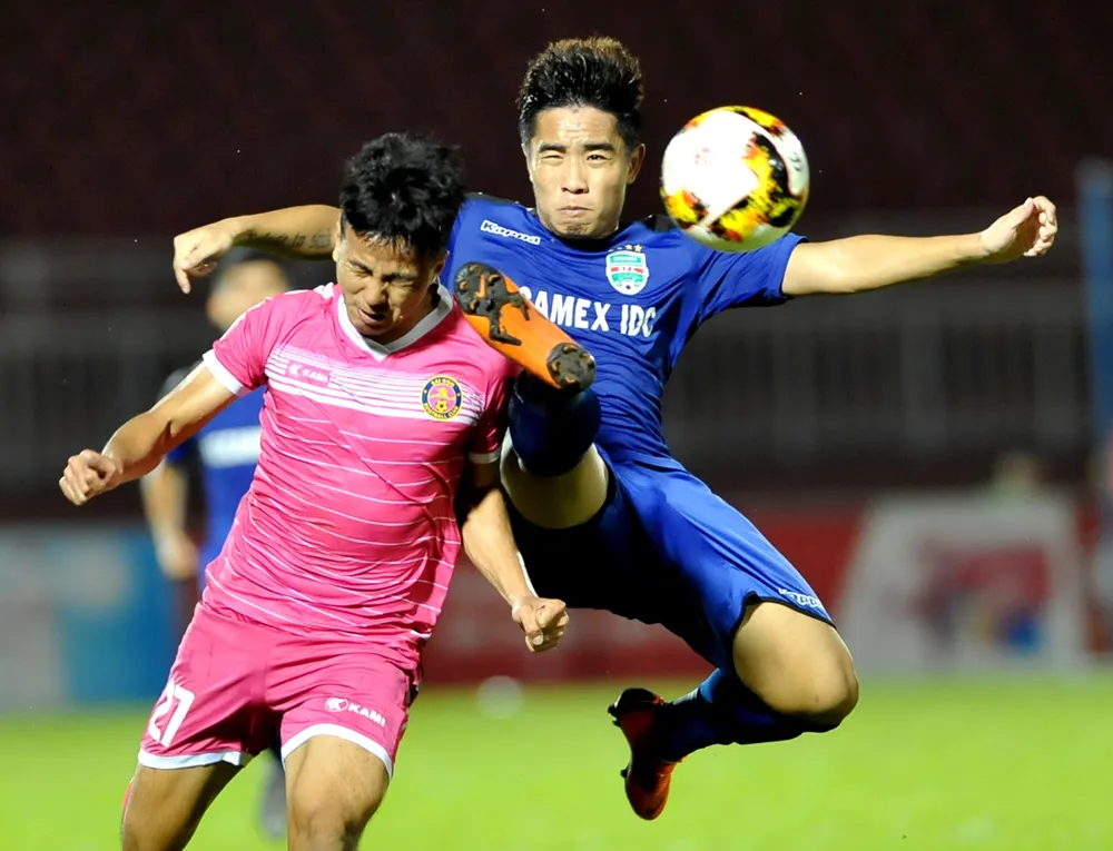 Hữu Sơn (27, CLB Sài Gòn) tranh bóng với Anh Tài của Bình Dương. Ảnh: NGUYỄN NHÂN