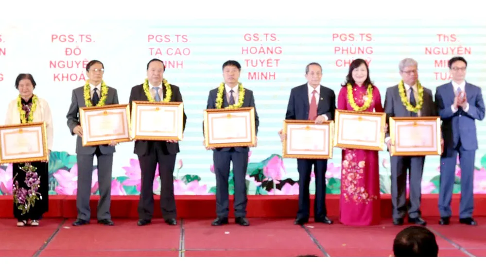 Phó Thủ tướng Vũ Đức Đam trao bằng khen tôn vinh 7 trí thức khoa học - công nghệ tiêu biểu năm 2019. Ảnh: TTXVN